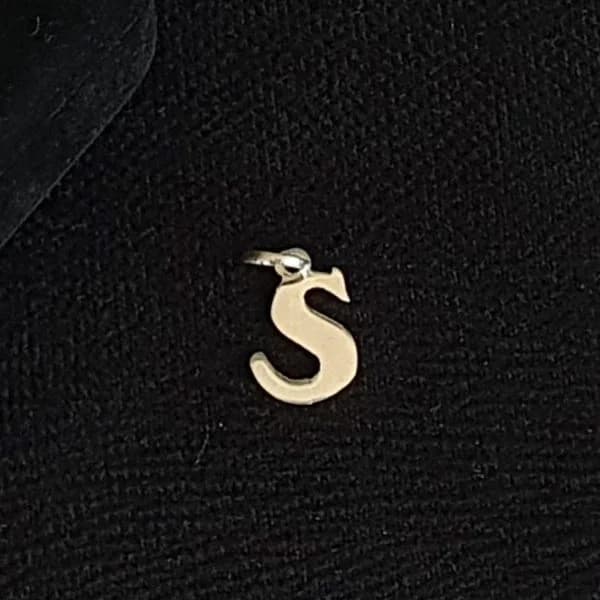 Dije silueta con la letra “S”