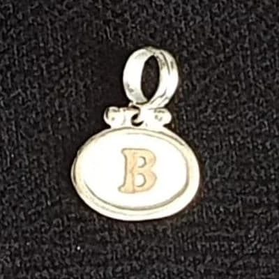 Dije silueta con le letra “B”